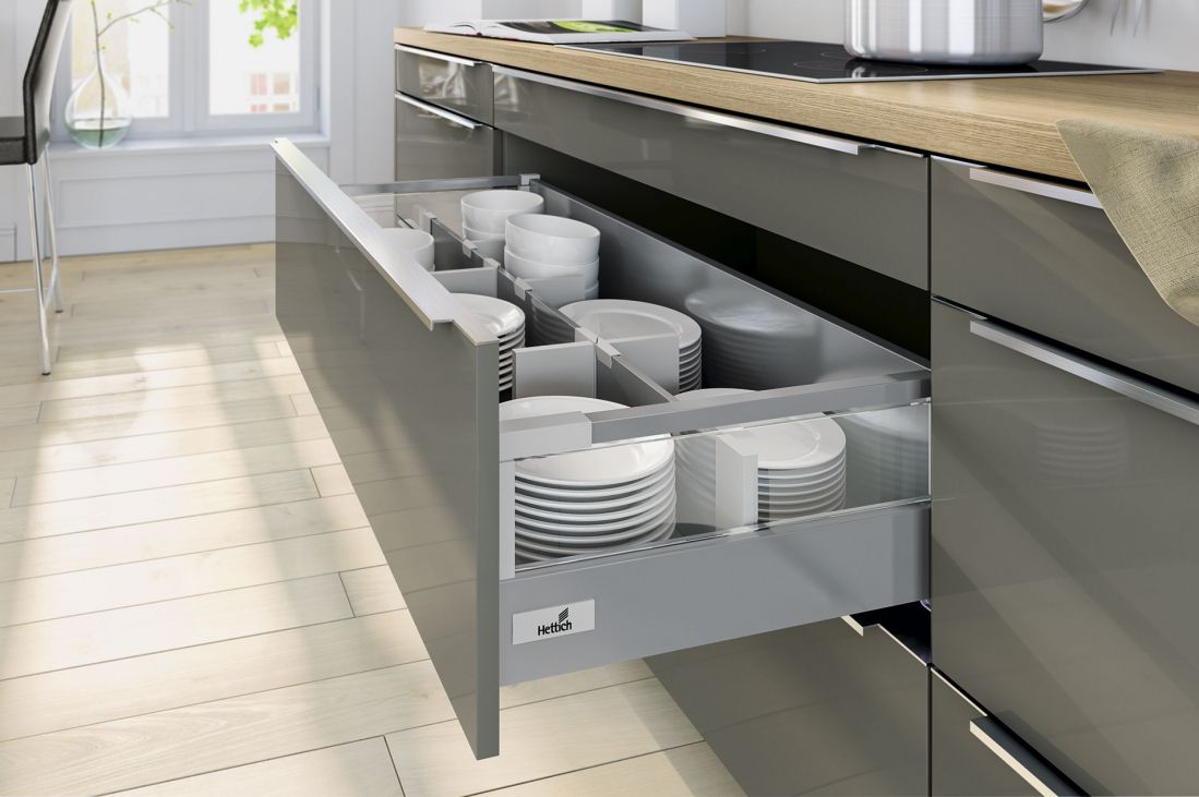 Cajonera línea de serie en color gris abierta en cocina de madera clara