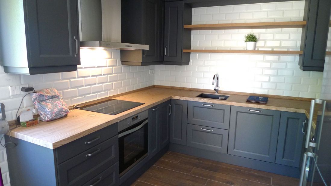 Cocina con muebles en color gris oscuro y encimera en madera de tono cobrizo