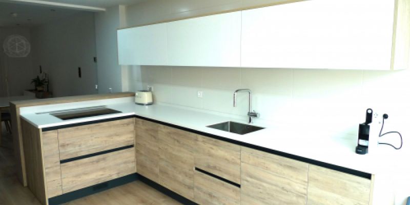 Cocina con muebles superiores en color blanco e inferiores en madera clara