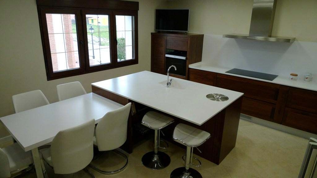 Cocina moderna en madera de color cobrizo y muebles de cocina y encimera en blanco