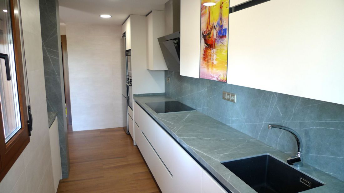 Cocina con muebles blancos y encimera en tono gris