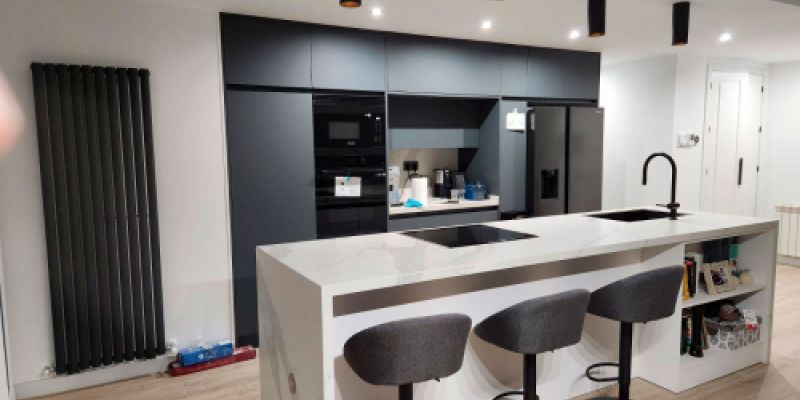 Cocina con muebles en gris y barra blanca con banquetas