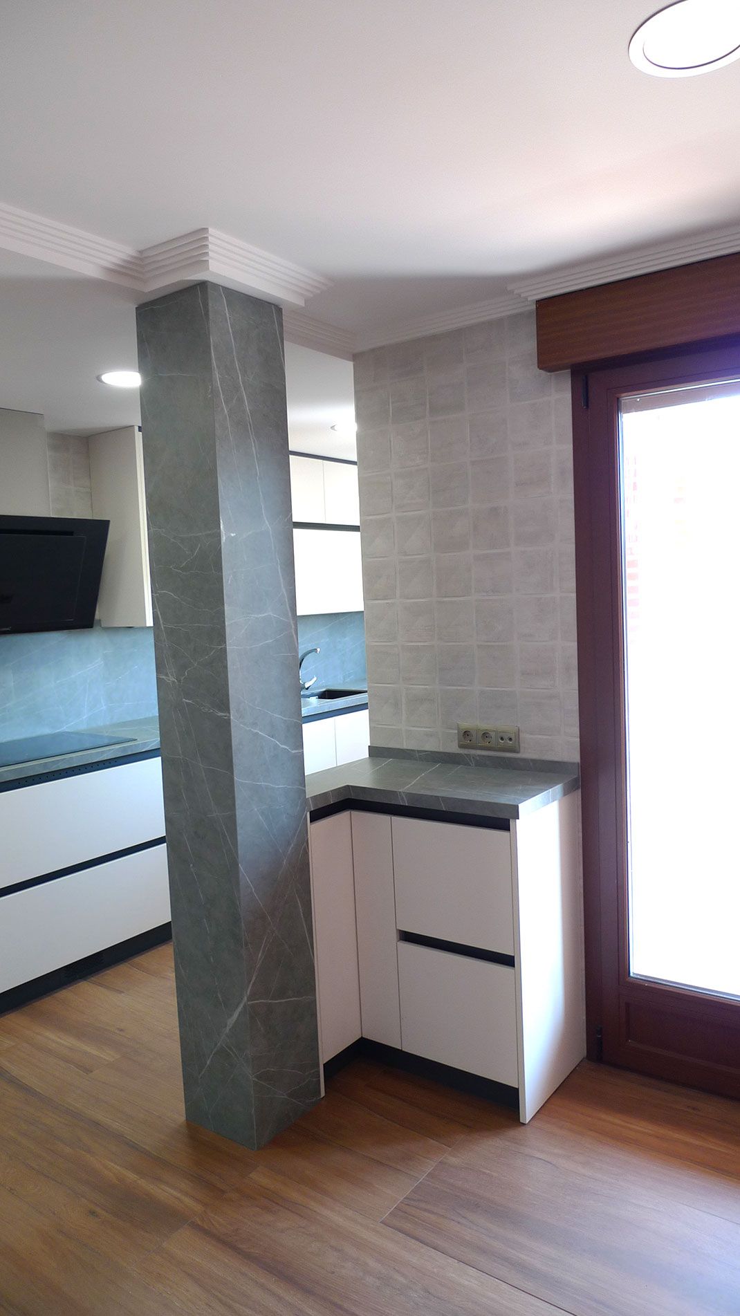 Muebles de cocina con columna a la izquierda y ventana a la derecha