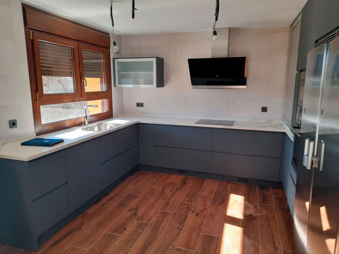 Cocina con muebles en color gris oscuro y encimera en tono claro