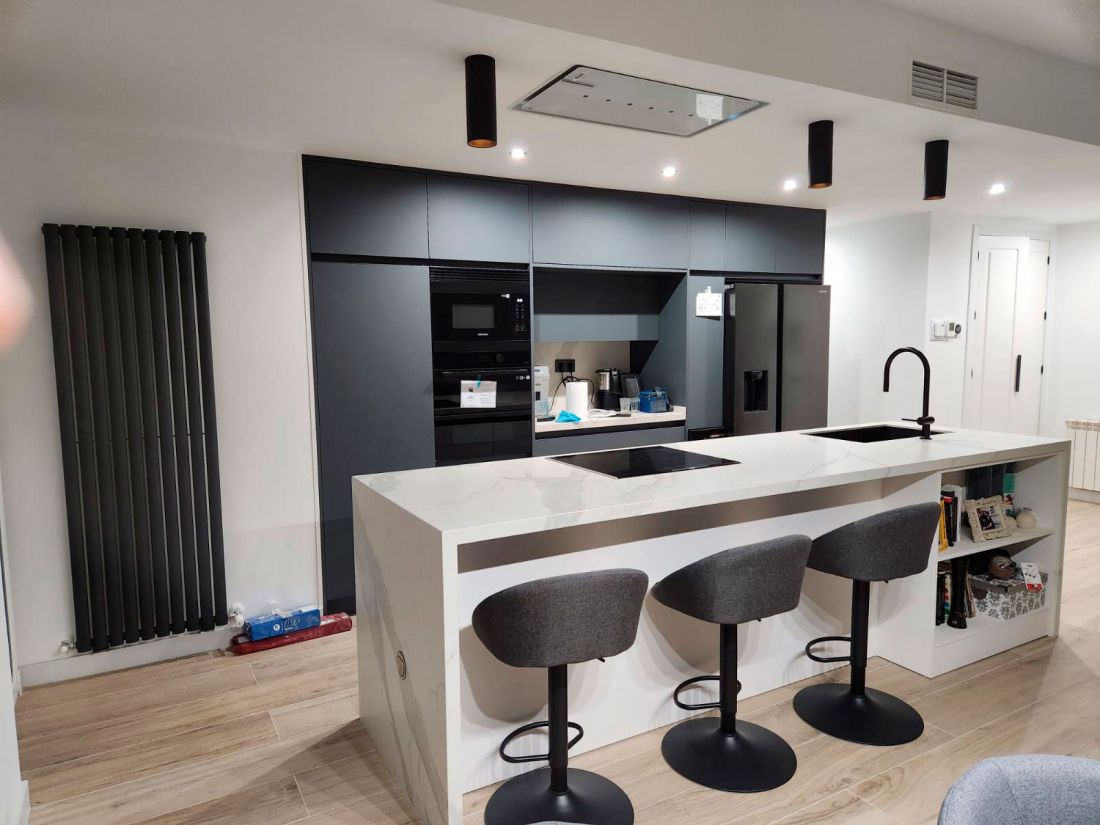 Cocina con muebles en gris y barra blanca con banquetas